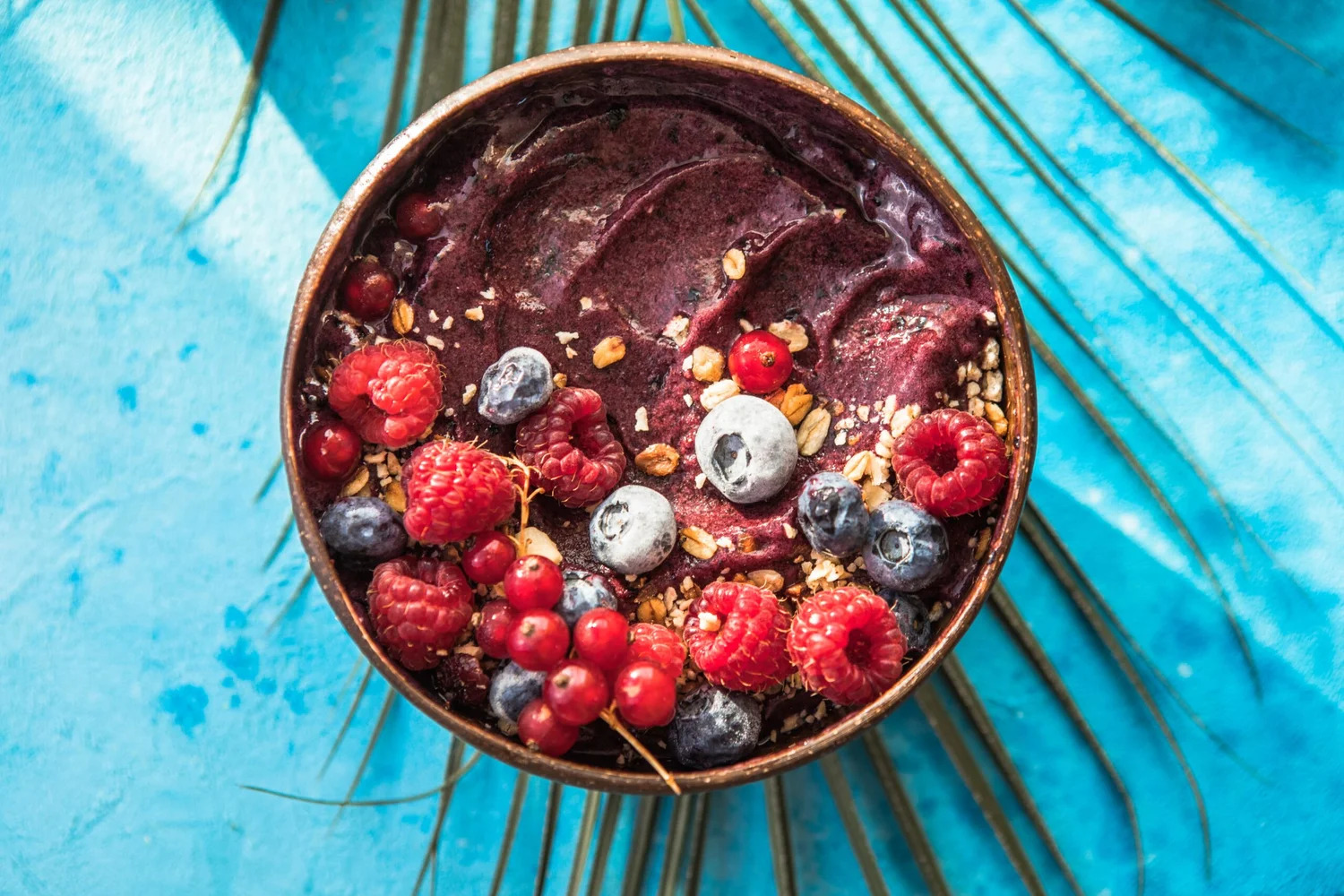 An acai bowl topped with raspberries and blueberries