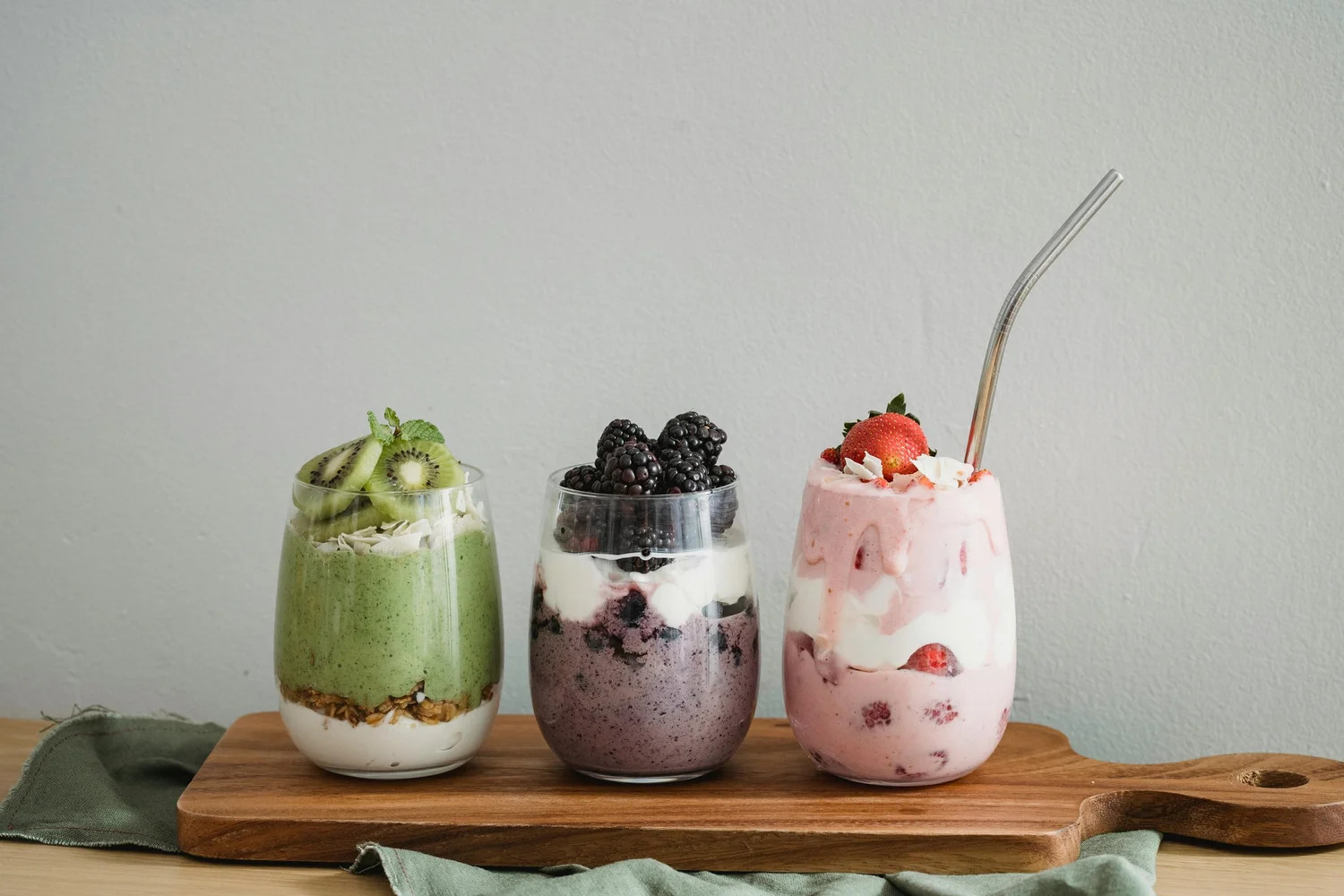 Three layered smoothie cups topped with fruit