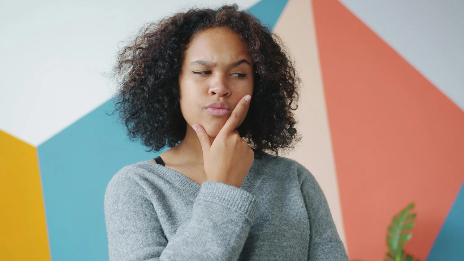 A woman resting her chin on her hand, deep in thought