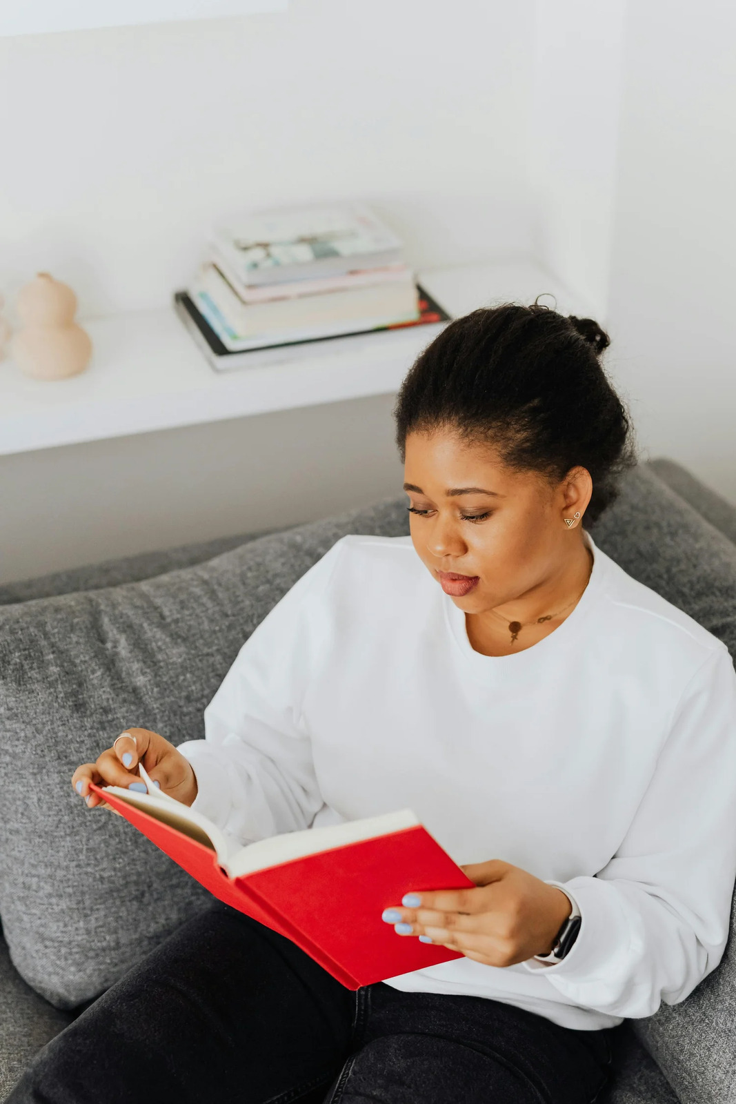 A woman reading a book on a sofa