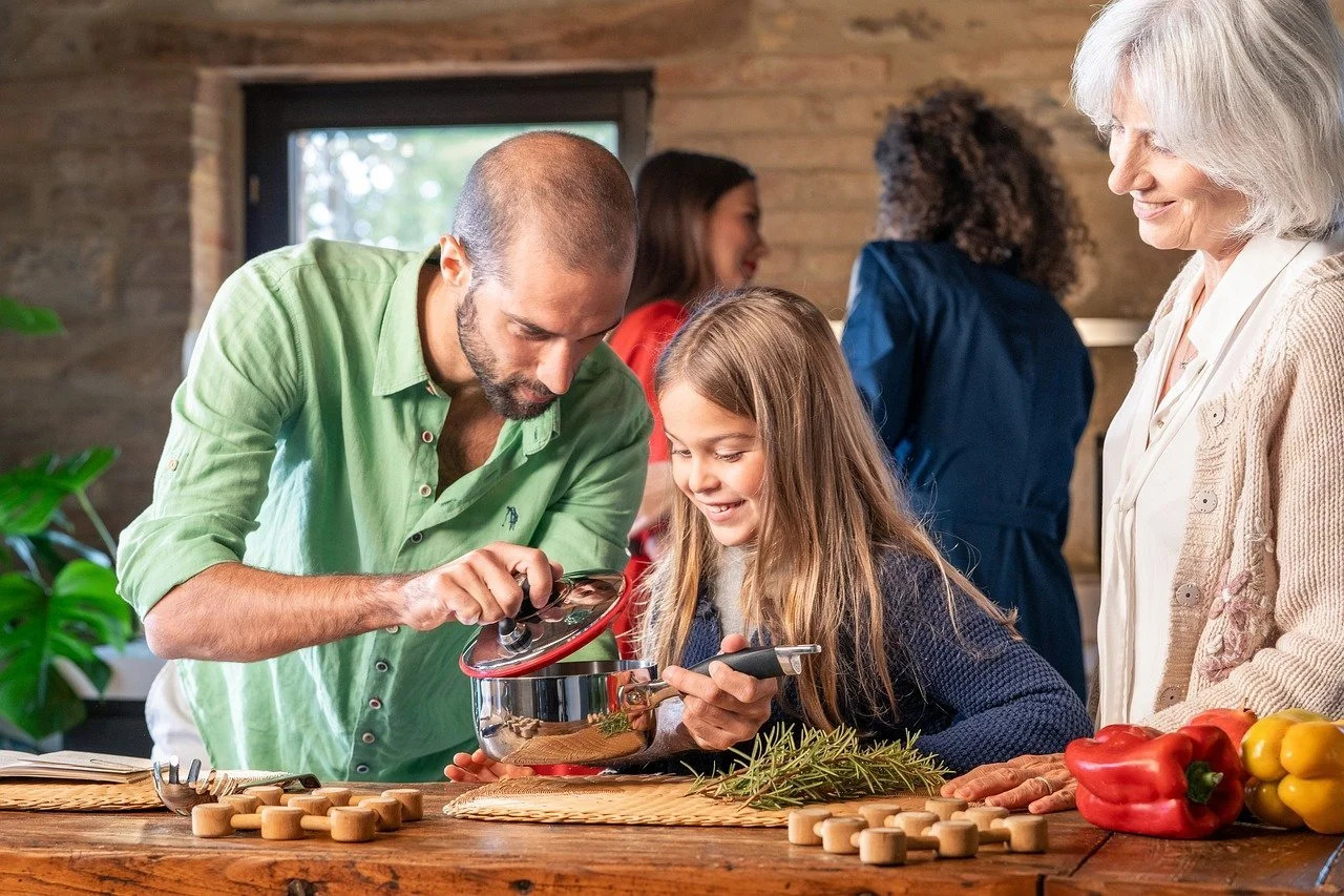 Three generations of a family cooking together in a kitchen