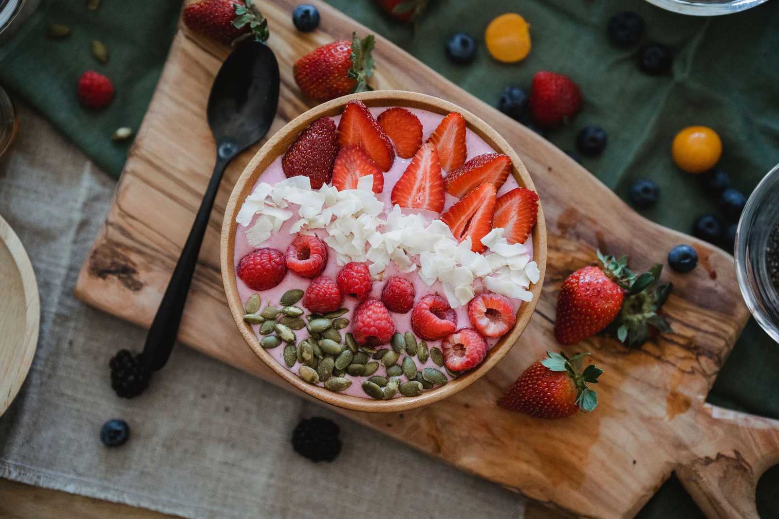 Overhead view of a fruit and seed bowl on a wooden board