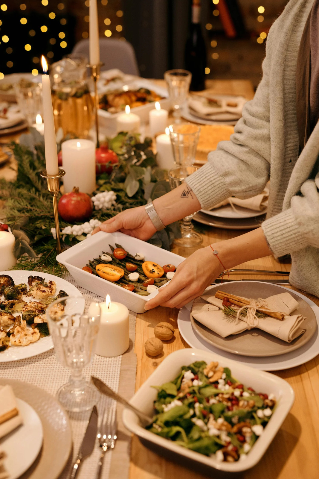A dish being passed across a festive dinner table