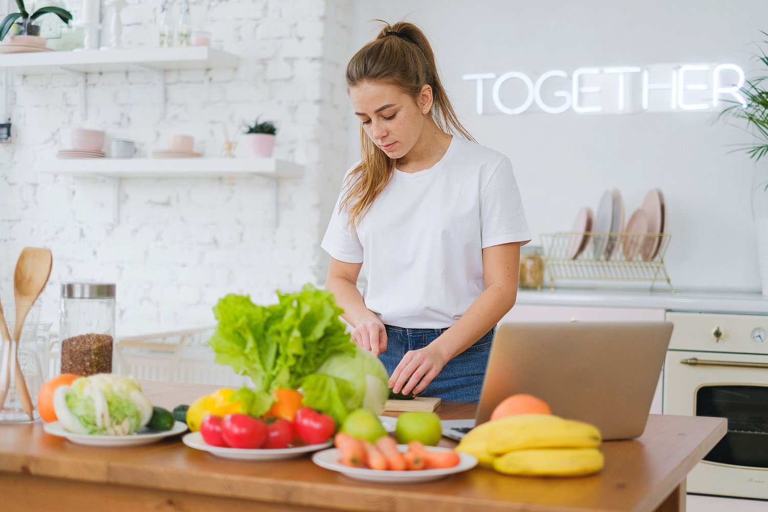 A young woman preparing vegetables at a kitchen counter