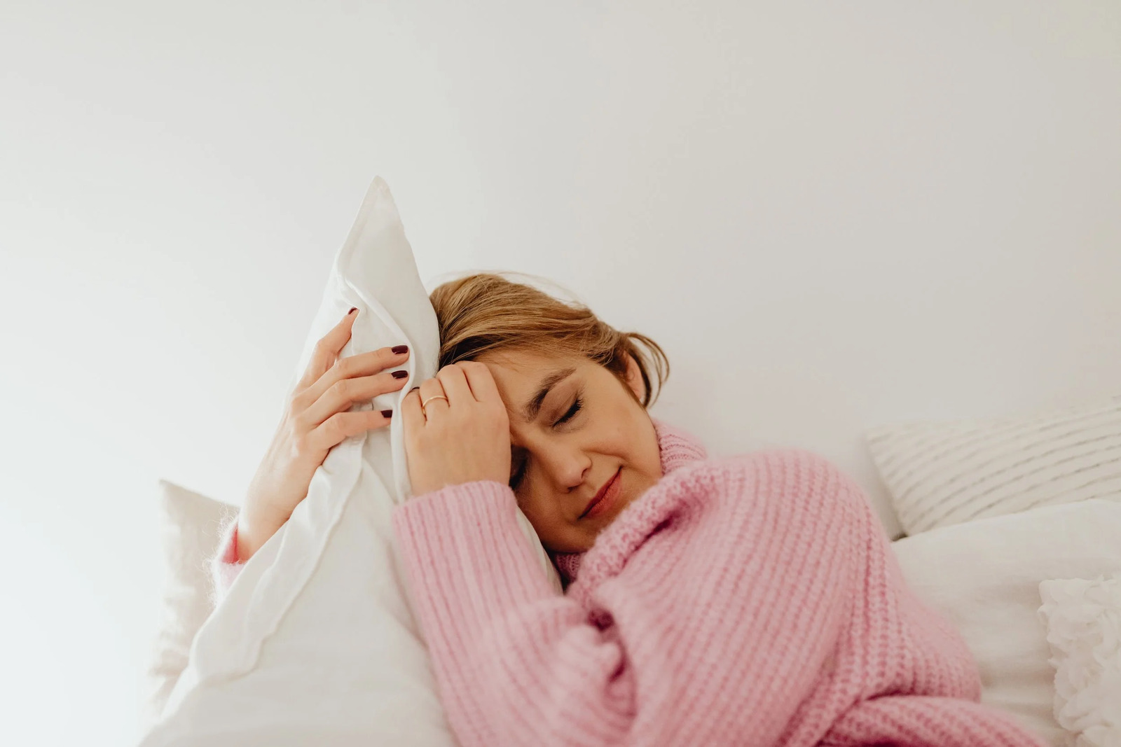 A woman lying awake in bed, resting her head on her arm