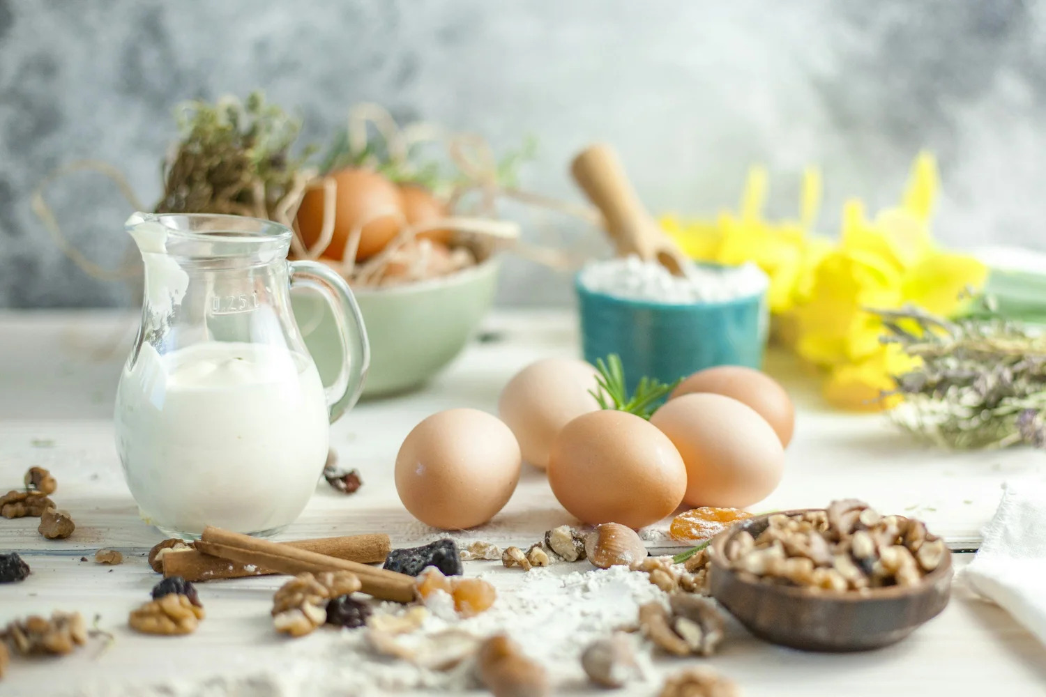 A jug of milk, eggs and nuts on a kitchen table