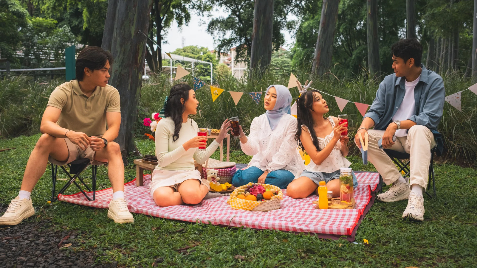 A family sharing a picnic on a checked blanket in a park
